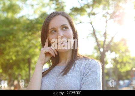 Nachdenklich, glücklich erwachsenen Frau an der Seite stehen in einem Park suchen Stockfoto