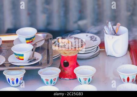 Traditionelle Tasse äthiopischen Kaffee mit aromatischen Essenz serviert. Festakt mit Weihrauch, Weihrauch und Myrrhe, entzündet durch eine heisse Kohle zu Produ Stockfoto