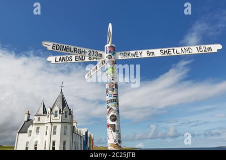 Britains landet End-Schild bei john o'groats in schottland mit blauem Himmel und Meer und Gras im Hintergrund Stockfoto
