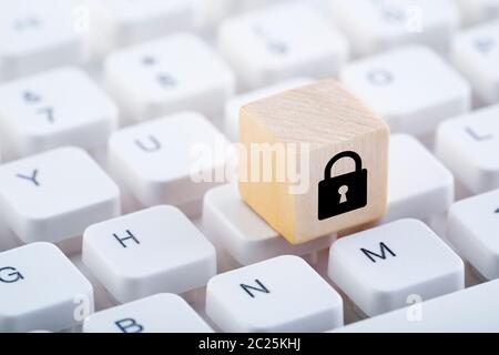 Holzblock mit Schloss Grafik auf PC-Tastatur. Computer Security Konzept. Stockfoto