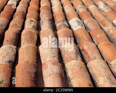 Eine Nahaufnahme von alten, gebogenen orangefarbenen Terrakotta-Pantilen auf einem Dach Stockfoto