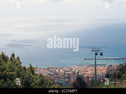 Ein Blick auf funchal madeira von monte mit der Seilbahn von der Stadt und einem leuchtend blauen, sonnendurchfluteten Meer Stockfoto