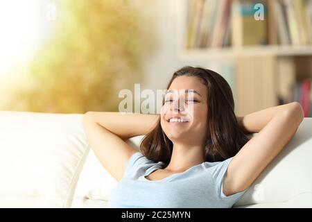 Happy girl ruht entspannt auf einer Couch im Wohnzimmer zu Hause Stockfoto