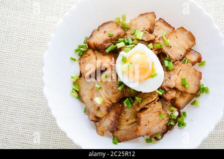 Schüssel mit Reis gekrönt mit gebratenen Schweinebauch Stockfoto