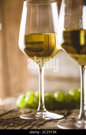 Wein. Glas Weißwein im Weinkeller. Alte Weißwein auf Holz. Stockfoto
