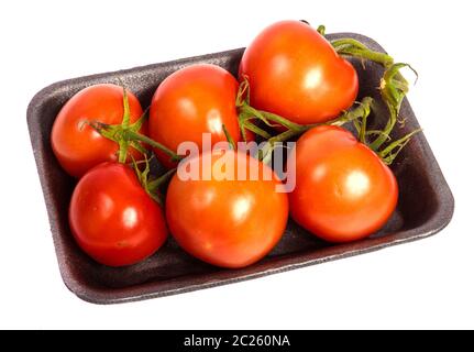 Reife rote Tomaten in einem dunklen Kunststoff Fach auf einem weißen Stockfoto