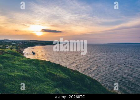 Landschaft des hügeligen Ufer Neben der Flüsse Mündung bei Sonnenuntergang Licht Stockfoto