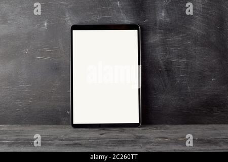 Elektronische Tablet mit einem leeren weißen Bildschirm vor einem schwarzen Kreidetafel, kopieren Raum Stockfoto