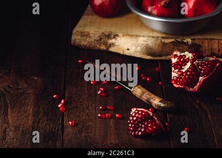 Granatapfel Obst mit Messer auf Holzmöbeln im Landhausstil Oberfläche. Stockfoto