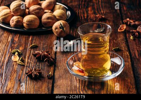 Orientalischer Kaffee mit Kardamom, Sternanis und getrocknete Kalk in armudu Glas über Holz- Oberfläche Stockfoto
