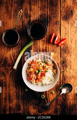 Rührei mit Tomaten, Lauch und weißer Reis. Türkischer Kaffee und geschnittene Zutaten. Stockfoto