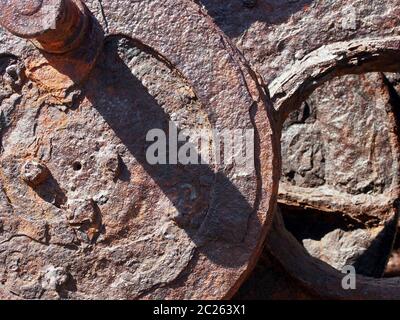 Korrodierte Eisenräder, die auf alten Industriemaschinen mit braunem Rost bedeckt sind Stockfoto