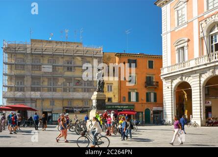 Touristen und Einheimische, zu Fuß und mit dem Fahrrad, genießen Sie einen sonnigen Tag an der Piazza Garibaldi in Pisa Italien mit einer Statue von Giuseppe Garibaldi in der Mitte Stockfoto