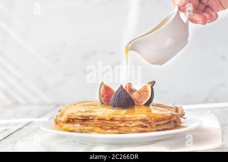 Stapel von hausgemachte Pfannkuchen mit der Frau die Hand gießen Süße nachfüllen Stockfoto