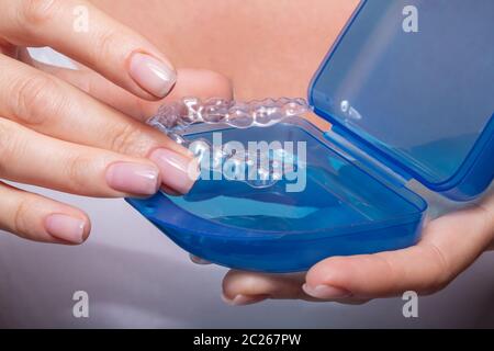 Woman's Hand Transparent Ausrichter in blaues Gehäuse Stockfoto