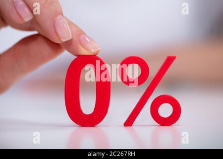 In der Nähe von Frau mit roten Null Prozent Symbol auf weißem Schreibtisch Stockfoto