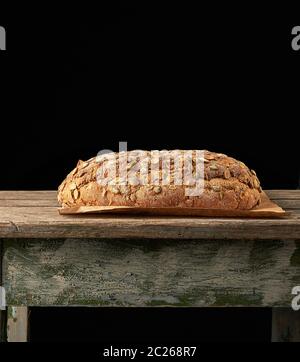 Gebackene oval Brot aus Roggen Mehl mit Kürbiskernen, schwarzer Hintergrund gemacht Stockfoto