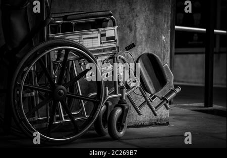 Rollstuhl gefaltet neben der Wand. Traurige Nachricht am Krankenhaus Konzept. Depression mit der Alterung der Gesellschaft. Einsame leere Rollstuhl. Medizinische Ausrüstung für Ser Stockfoto