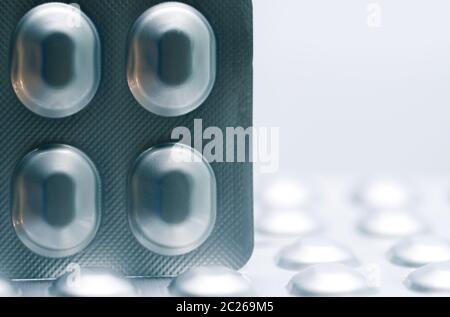 Makroaufnahme detail von Tablet-Pillen in Silber Aluminium Blister Verpackung auf unscharfen Hintergrund der Packung Pillen Stockfoto