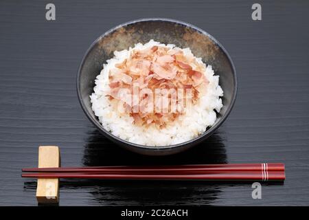 Japanisches Essen, Katuobushi auf gekochten Reis weiß auf schwarzem Hintergrund Stockfoto