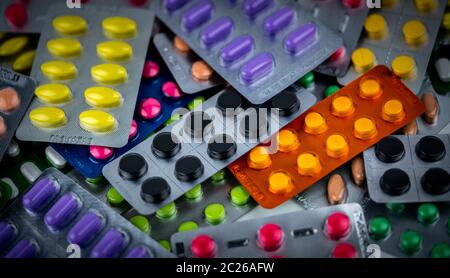 Stapel der Bunten tabletten Pille in Blisterverpackung. Pharmazeutische Industrie Konzept. Apotheke Apotheke. Schmerzmittel und Wechselwirkungen mit charcoa Stockfoto
