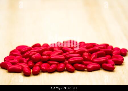 Red Niere Zucker überzogene Tabletten Pillen auf Holz Tisch mit Platz kopieren Stockfoto