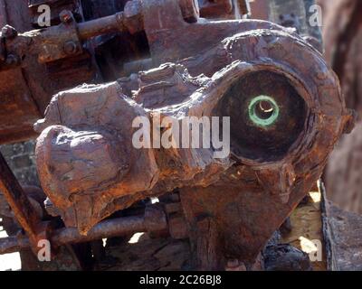 Nahaufnahme eines großen rostigen Industriemotors mit Schrauben und Zahnrädern im Freien Stockfoto