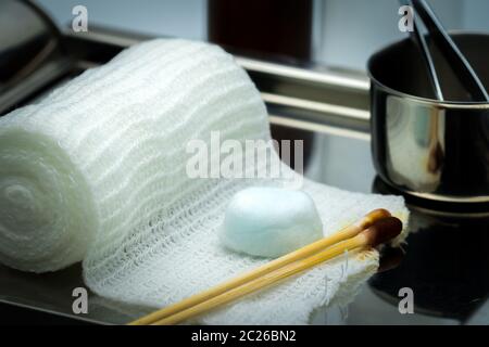 Wundversorgung Abrichten auf Platte aus rostfreiem Stahl. Tupfer mit Alkohol, Wattestäbchen mit Povidon Jod, Pinzette und Bandage entsprechen. Stockfoto