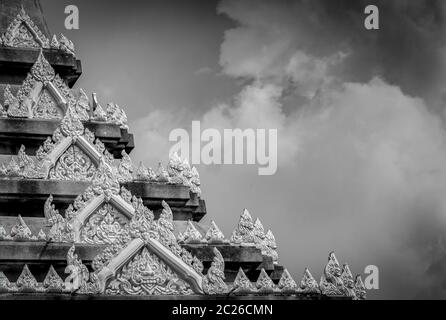 Closeup Detail der Tempel in Thailand. Kunst Muster. Traditionelle Thai Stil Skulptur gegen Wolken und Himmel. Schwarz und Weiß, Szene der Tempel detail. Ba Stockfoto