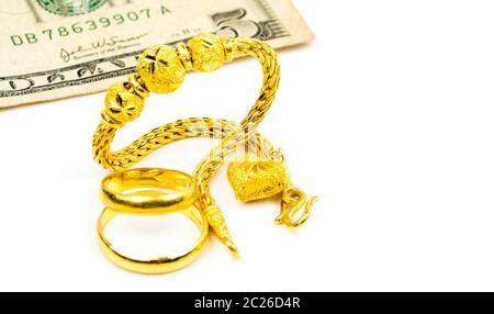 Thai Stil Gold Schmuck Armband, Paar gold-ring und Dollar Bill auf weißem Hintergrund mit Kopie Raum isoliert, nur Ihren eigenen Text hinzu. Chinese New Stockfoto