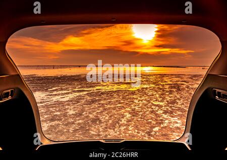 Schöne Meerblick von innen Kofferraum. Meerblick mit orangefarbenen Himmel und Wolken bei Sonnenuntergang am Strand. Freiheit Sommer Reisen mit Reise auf Vac Stockfoto