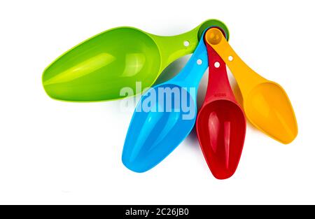 Set aus bunten Kunststoff Messlöffel auf weißem Hintergrund mit Schatten isoliert. Grün, Blau, Rot und Orange Kunststoff Messlöffel. Stockfoto