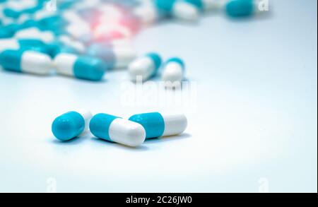 Selektiver Fokus auf blaue und weiße Kapseln Pille verteilt auf weißem Hintergrund. Global Healthcare. Antibiotika Resistenzen. Antimikrobielle Kapsel Pille Stockfoto