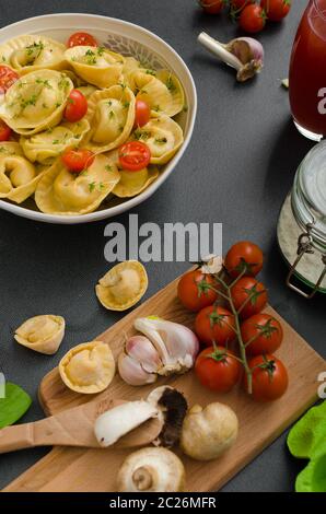 Hausgemachte Tortellini gefüllt, Pilze und Tomaten mit Feta-Käse Stockfoto