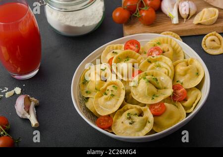 Hausgemachte Tortellini gefüllt, Pilze und Tomaten mit Feta-Käse Stockfoto