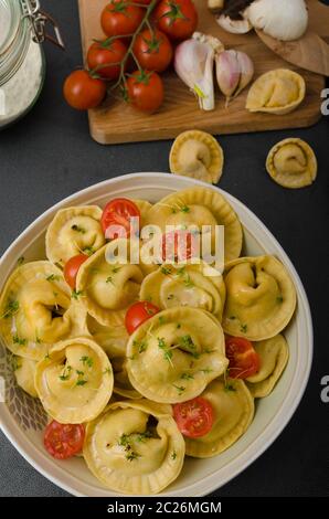 Hausgemachte Tortellini gefüllt, Pilze und Tomaten mit Feta-Käse Stockfoto