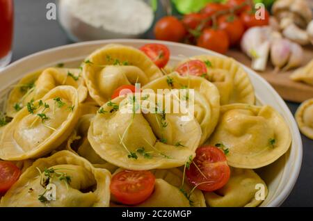 Hausgemachte Tortellini gefüllt, Pilze und Tomaten mit Feta-Käse Stockfoto