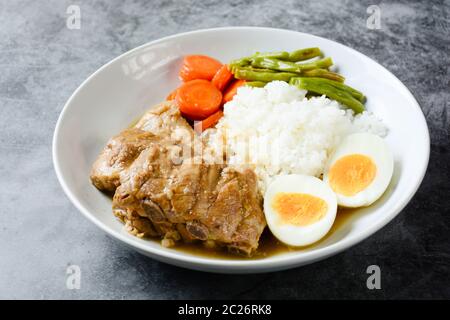 Gebackene Schweinerippchen mit Reis, gekochtes Ei und Gemüse Stockfoto