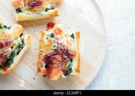 Spinat überbacken mit Käse, Wurst auf Baguette, Französisches Brot Stockfoto