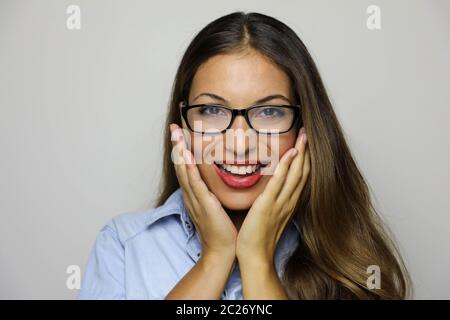 Business Frau glücklich hält Wangen durch die Hände. Schöne Mädchen mit Brille lächelnd in die Kamera. Ausdrucksstarke Mimik Geschäftsfrau. Stockfoto