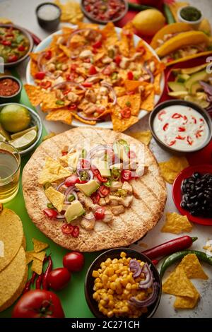 Verschiedene frisch zubereitete mexikanische Speisen. Auf einem bunten Tisch platziert Stockfoto