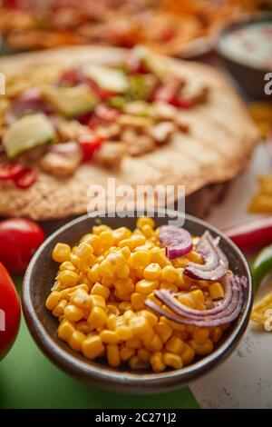 Nahaufnahme von Maiskörnern mit verschiedenen frisch zubereiteten mexikanischen Lebensmitteln Sortiment Stockfoto