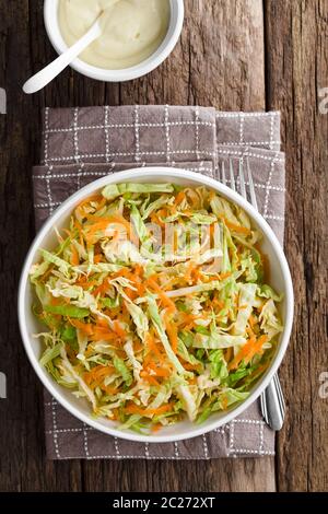 Krautsalat aus frisch geschreddertem Weißkohl und geriebener Karotte mit hausgemachtem Salat-Dressing auf Mayonnaise-Basis an der Seite, fotografiert Overhead (SE Stockfoto