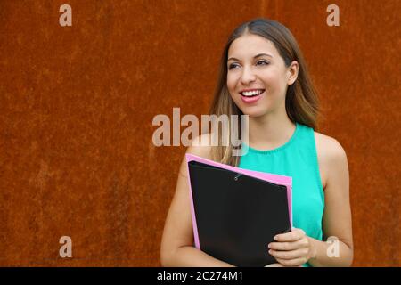Attraktive Frau zu Fuß auf der Straße hält Ordner und auf der Seite der Kopie. Stockfoto