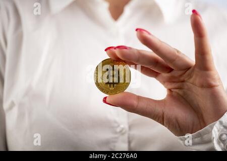 Bitcoin Münze in der Hand der Frau Stockfoto