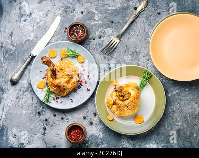 Hähnchenschenkel in Blätterteig. Hühnerbein in Blätterteig gebackenes Huhn auf dem Tisch. Stockfoto