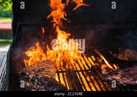 Fleisch Kochen auf einem Grill mit Flammen Stockfoto