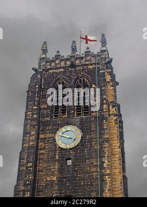 Der Turm und die Uhr auf halifax Münster in West yorkshire gegen einen grau bewölkten Himmel mit einer englischen Flagge Stockfoto