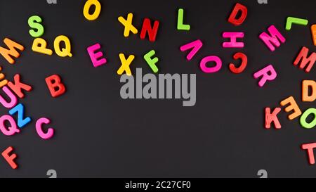 Bunte plastik Buchstaben des englischen Alphabets auf einem schwarzen Kreidetafel, Kopieren, Zurück zur Schule Stockfoto