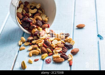 Mix aus verschiedenen Nüssen und Rosinen auf blauen Tabelle. Stockfoto